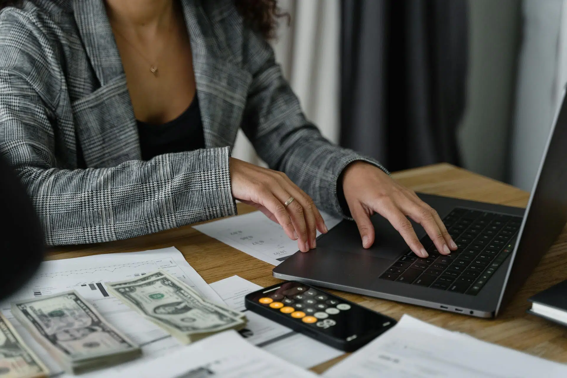 A woman working on here laptop, processing payroll.